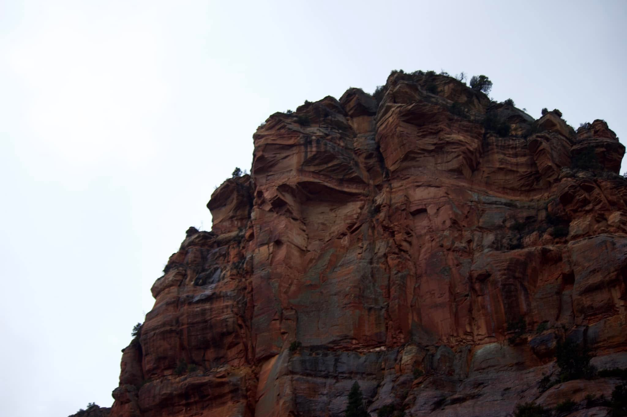 Red sandstone cliff face rising against pale sky