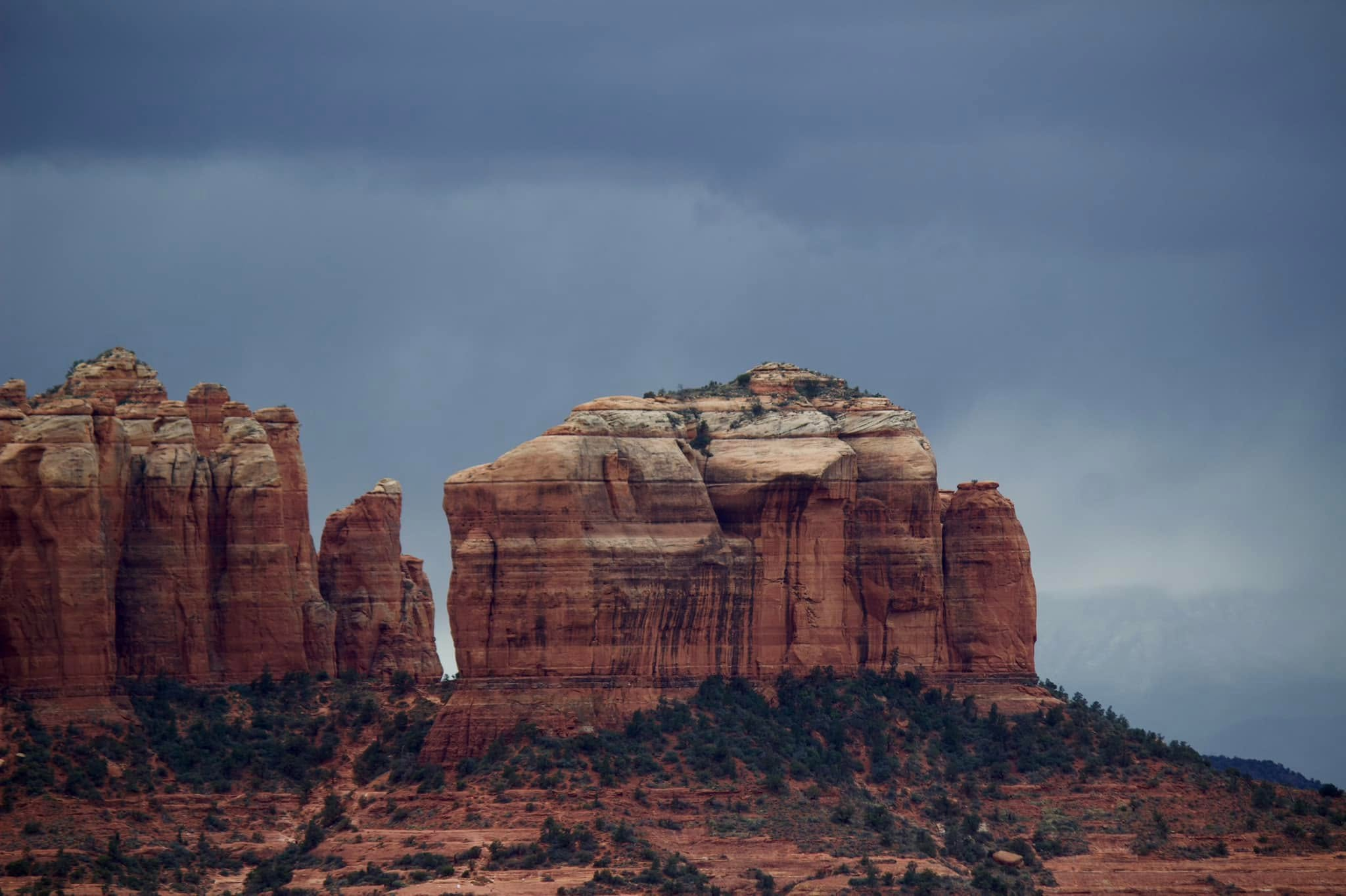 Sedona red rock formation under dark storm clouds
