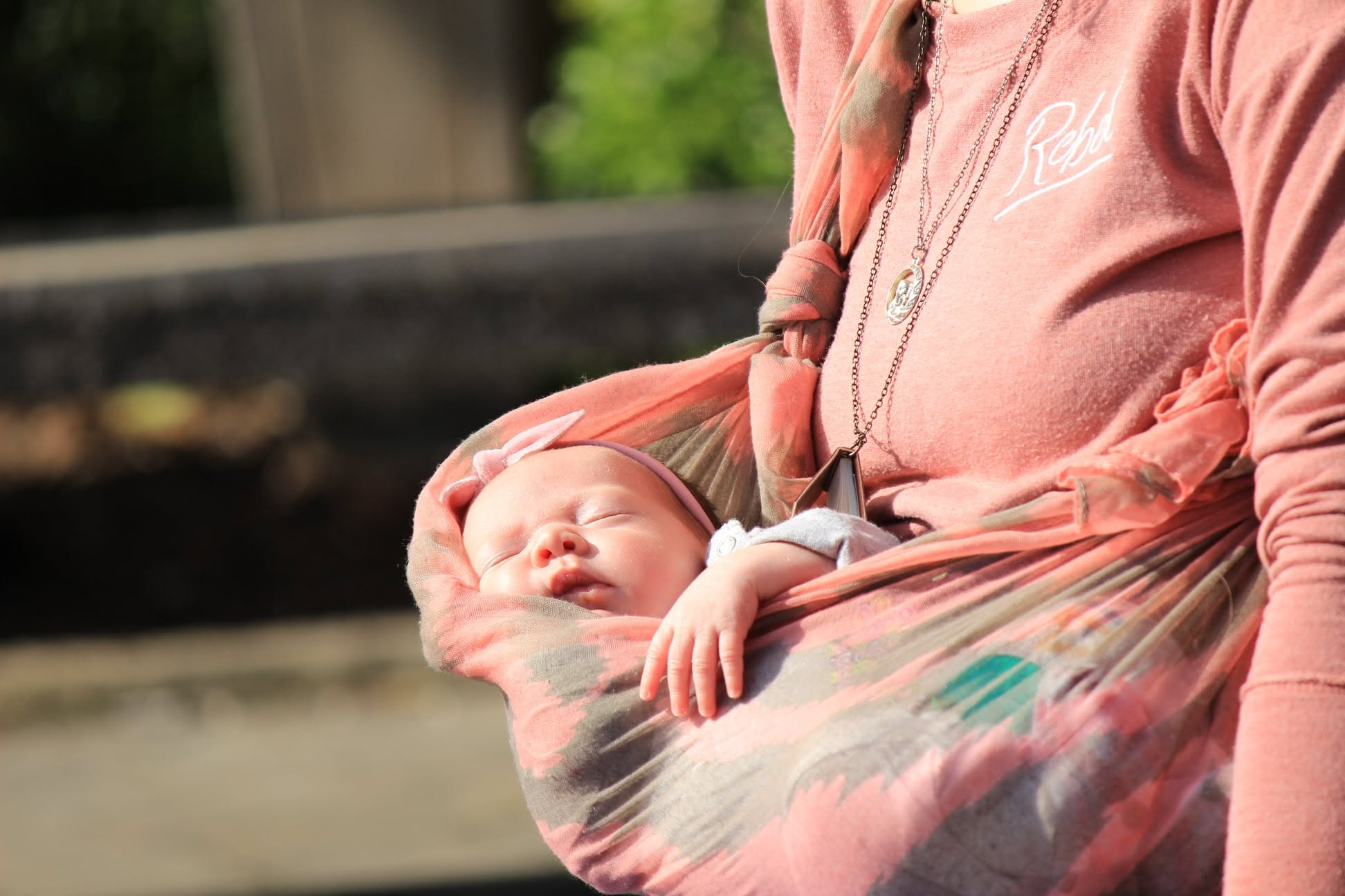 Newborn sleeping in a wrap sling
